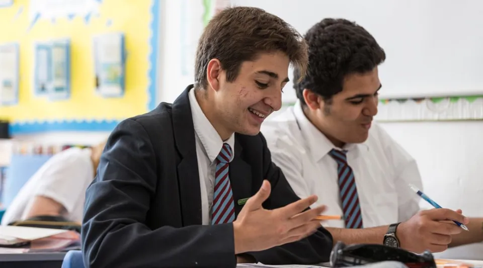 Due studenti della St. John’s School Sidmouth lavorano insieme a un compito alla scrivania.
