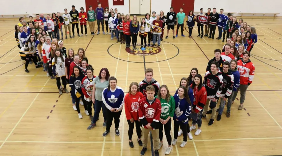 Studenti della Gravenhurst High School formano un cuore con i loro corpi nella palestra.