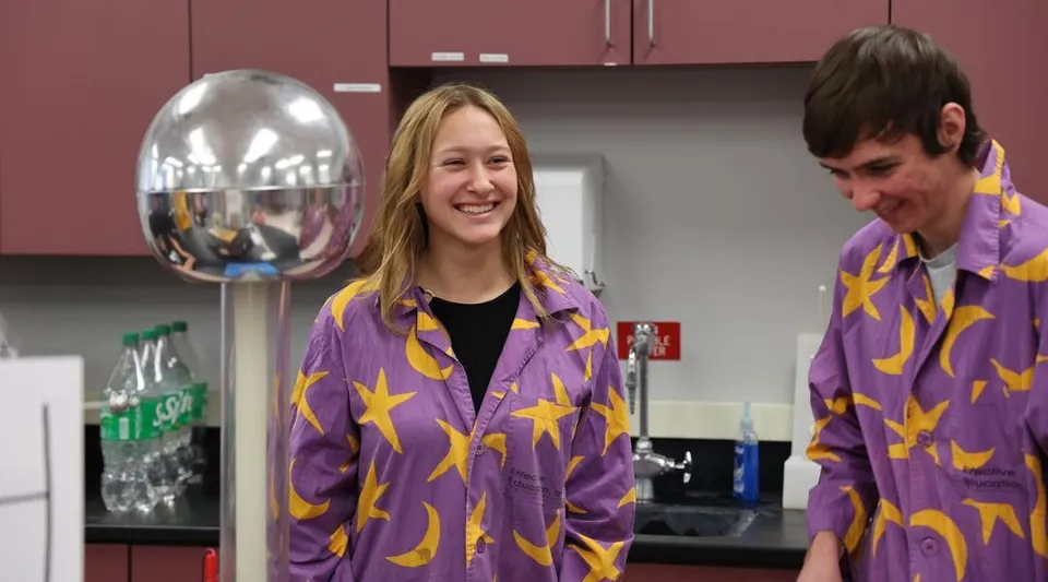 Due persone con giacche stellate si trovano in una stanza con vari oggetti al Boise School District.