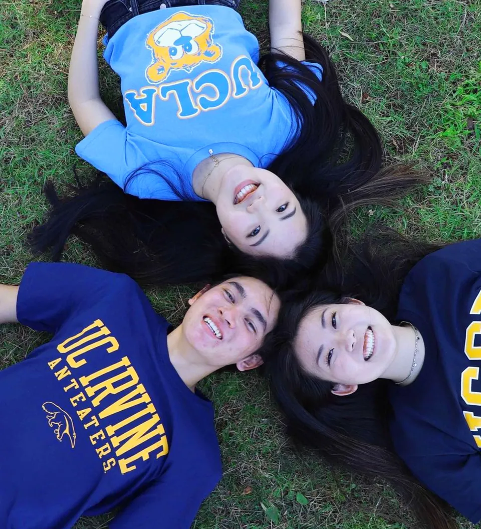 Tre studentesse della Torrance High School sono sdraiate sorridenti sull'erba e guardano verso la fotocamera.