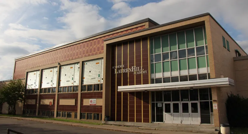 Il grande edificio in mattoni della LaurenHill Academy si trova davanti a un cielo nuvoloso.