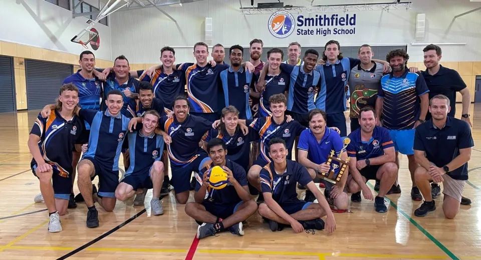 Un gruppo di studenti con i loro allenatori posa nella palestra della Smithfield State High School.