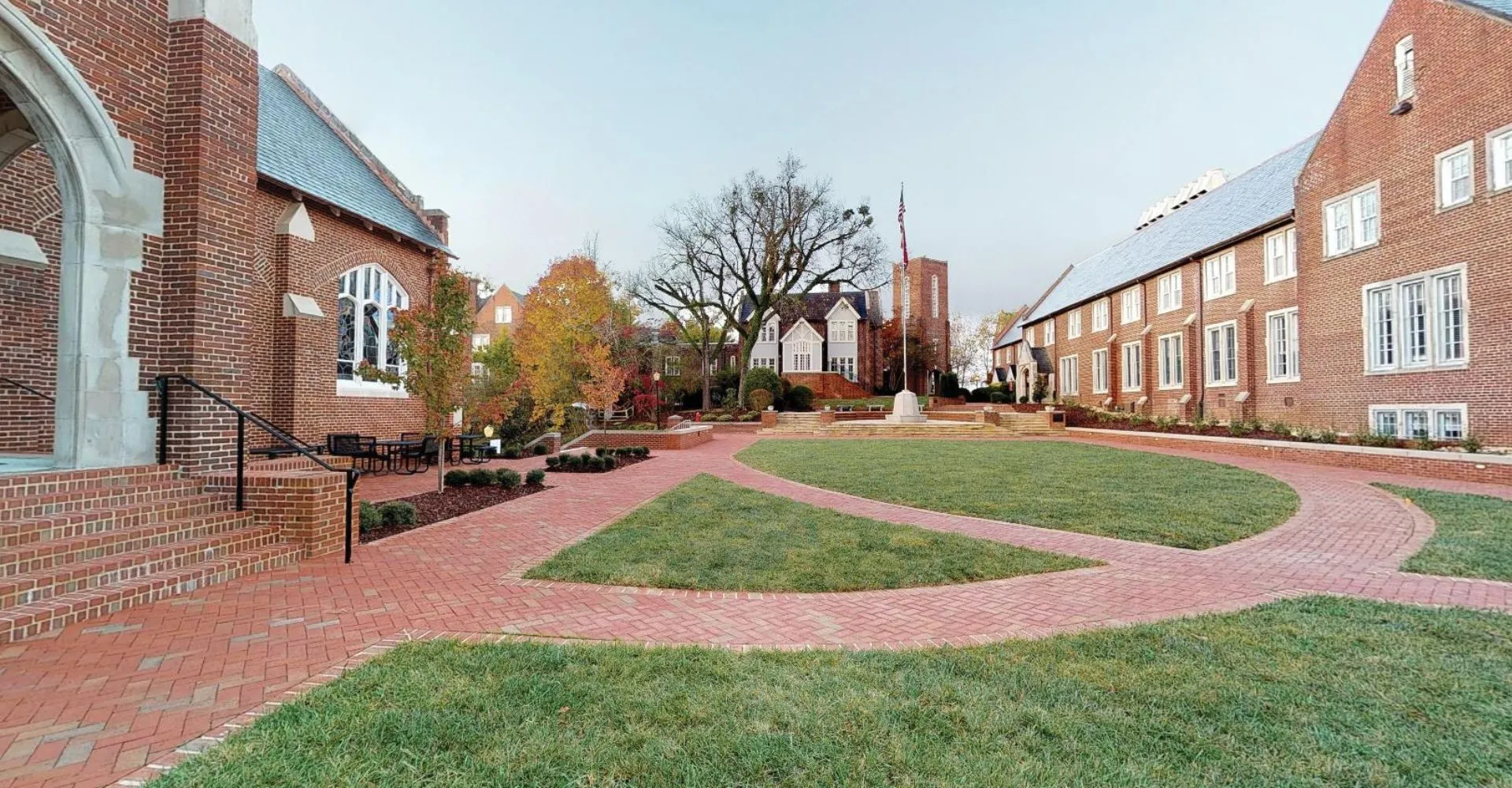 Un viale pavimentato in mattoni attraversa un cortile verdeggiante nel campus della Baylor School.