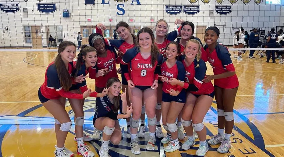 Un gruppo di studentesse di pallavolo della Providence Christian Academy posa insieme su un campo da basket.