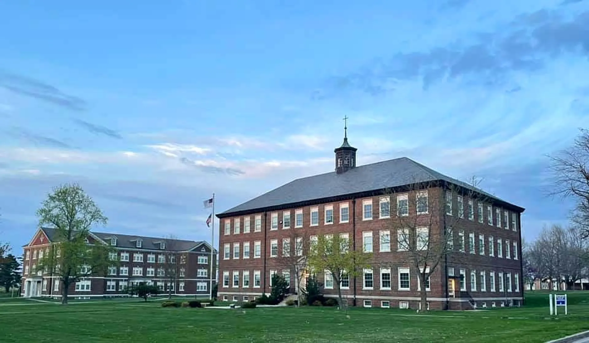 L'edificio in mattoni a più piani con la torre dell'orologio nel campus della Saint Paul Lutheran High School è circondato da un prato.