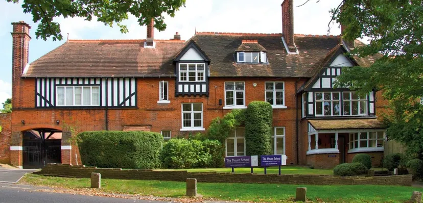 L'edificio in stile Tudor della Mill Hill International School è circondato da una rigogliosa vegetazione e da un prato ben curato.