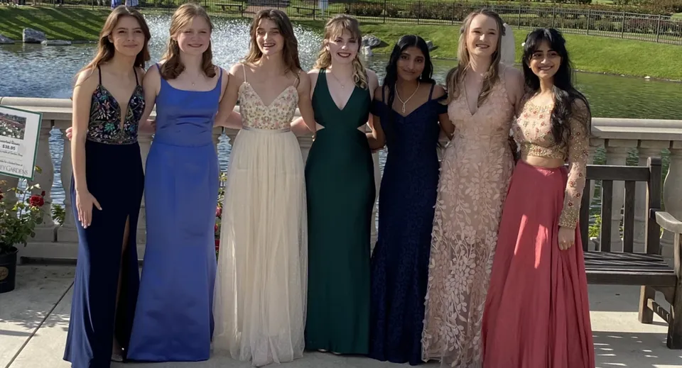 Un gruppo di giovani donne in abito da sera formale si trova davanti a uno sfondo paesaggistico nel campus della Presentation Secondary School Thurles.