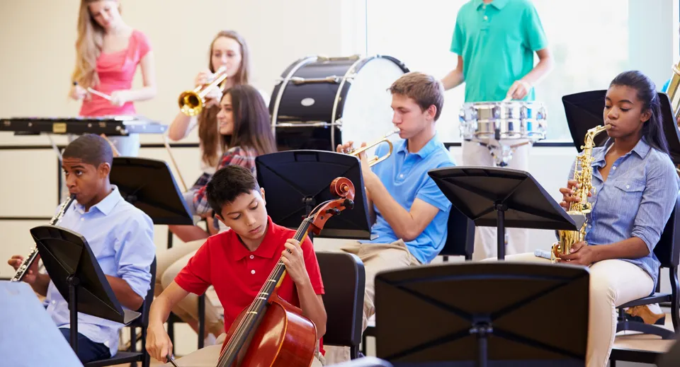 Un gruppo di studenti della Indooroopilly State High School suona diversi strumenti musicali in classe.