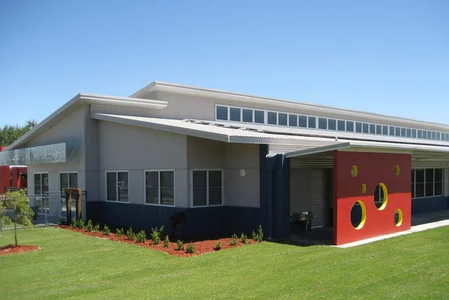 L'edificio moderno della Georgiana Molloy Anglican School con un elemento di parete rosso e un prato verde.