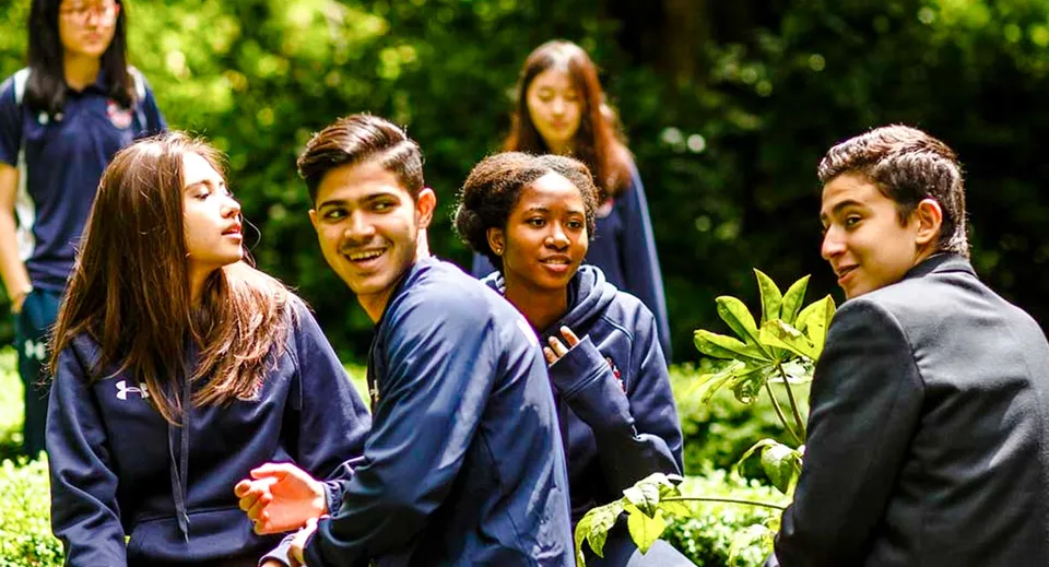 Studenti della Mill Hill International sono insieme in un'area verde all'aperto.