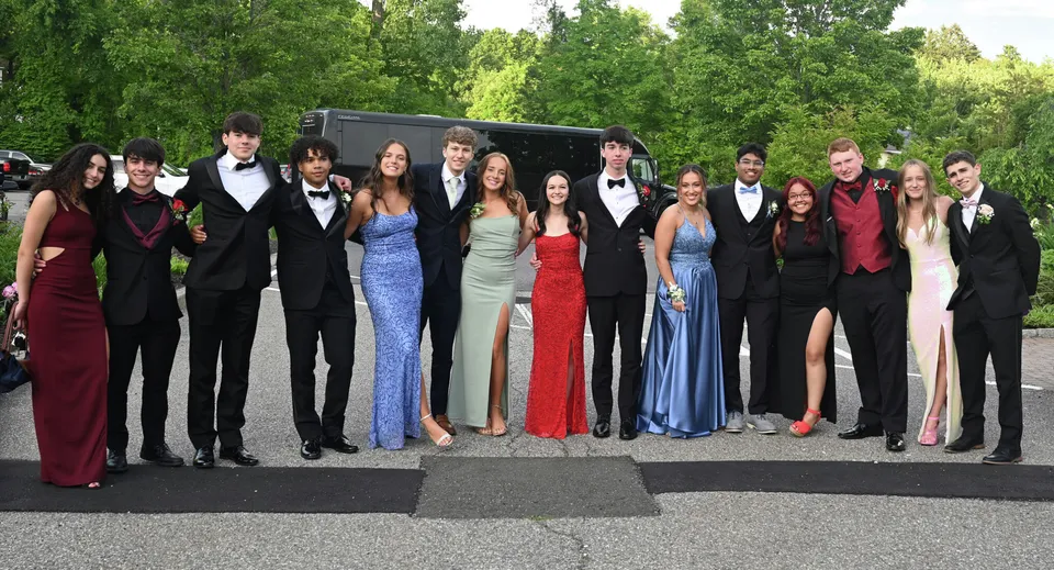 Un gruppo di persone vestite in modo formale posa davanti a uno sfondo alberato all'interno della Wilson's Hospital School.