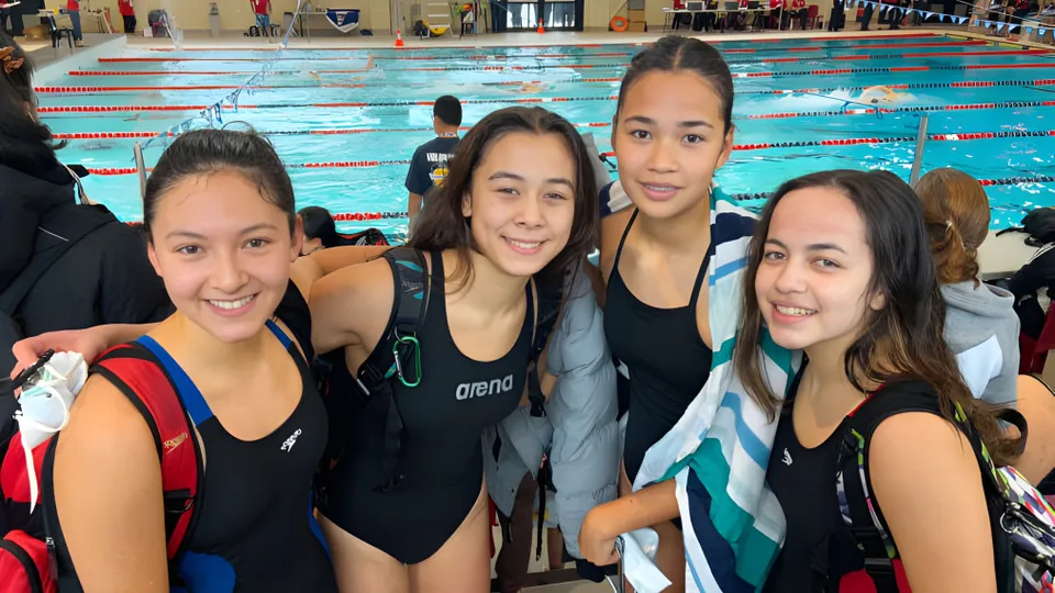 Un gruppo di studentesse della École Secondaire R.A. McMath Secondary School posa davanti alla piscina.
