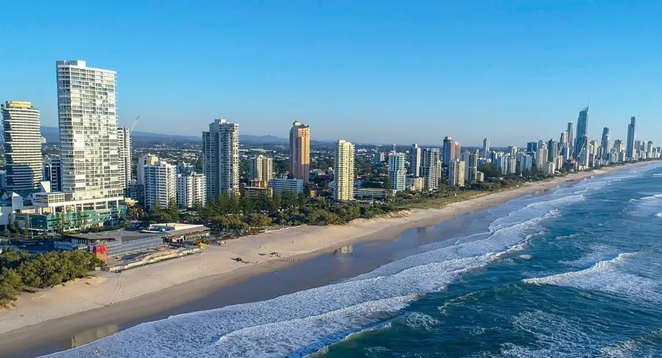 Vista aerea di una vivace città costiera con grattacieli e spiaggia, vicina alla Maroochydore State High School.