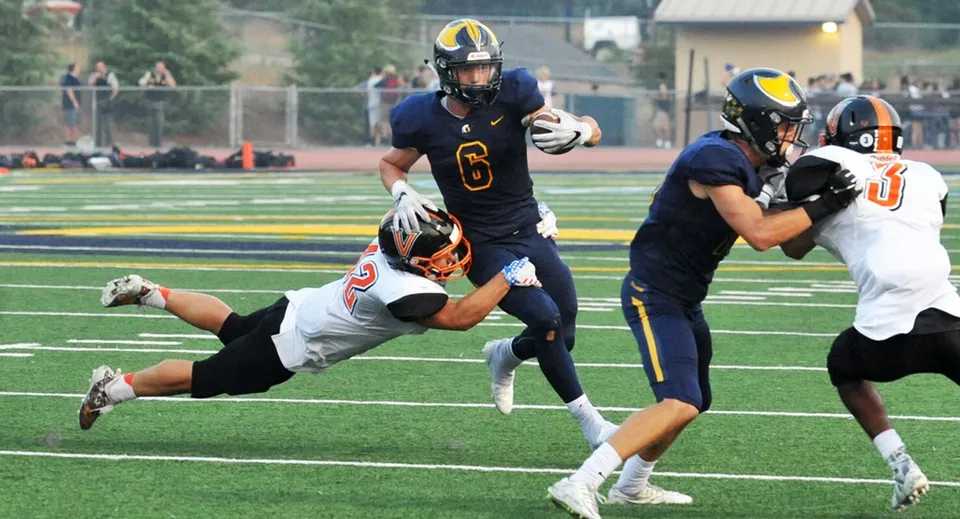 Studenti della Oakridge Secondary School giocano ad American Football durante un'intensa partita sul campo.
