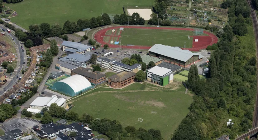 Il campus della Canterbury High School visto dall'alto, con edifici scolastici, campi sportivi e una pista di atletica.