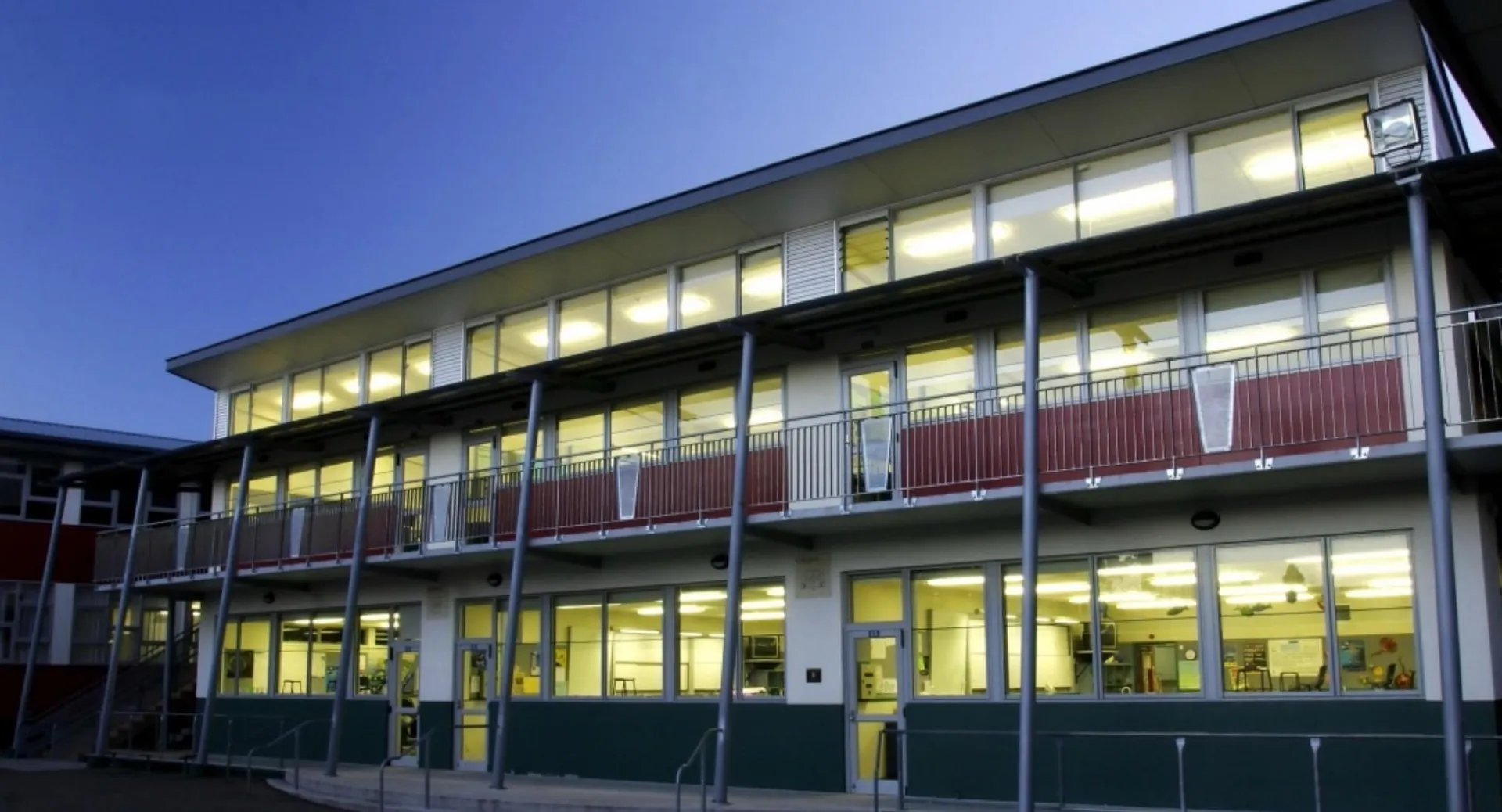 L'edificio a più piani dell'Otumoetai College con grandi finestre e uno zoccolo verde davanti a un cielo azzurro.