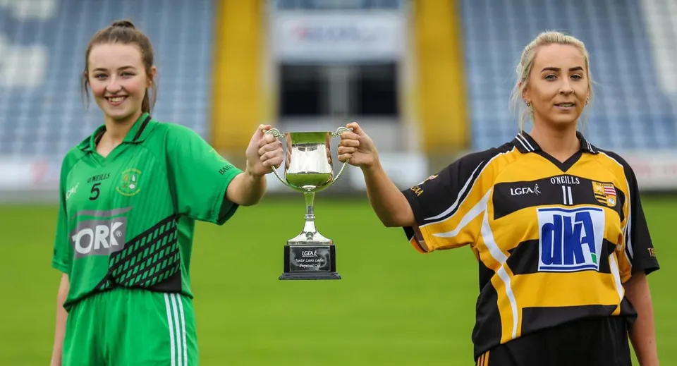 Due studentesse della St. Mary's Holy Faith (Killester) tengono insieme un trofeo sul campo da gioco.