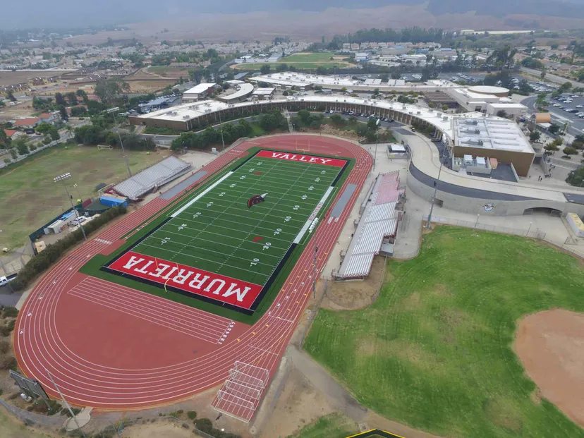 Vista aerea del grande stadio sportivo con campo da calcio rosso e pista di atletica nel Murrieta Valley Unified School District.