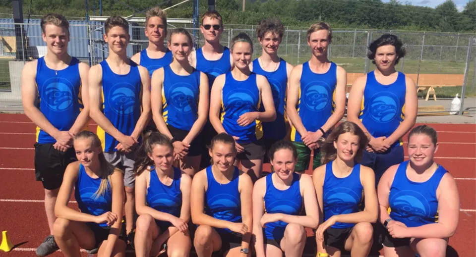 Un gruppo di giovani studentesse in divisa blu si trova sul campo sportivo della Brooks Secondary School.