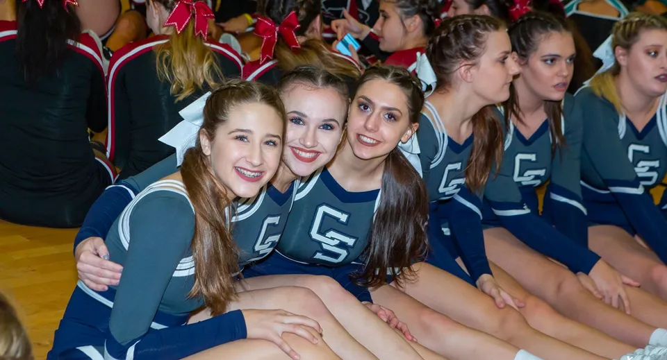 Un gruppo di giovani cheerleader posa nella palestra del Cave Creek Unified School District con le proprie divise coordinate.