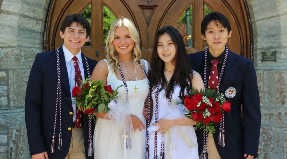 Quattro studenti della Shattuck-St. Mary's School si trovano davanti a un arco di pietra e tengono in mano rose rosse.