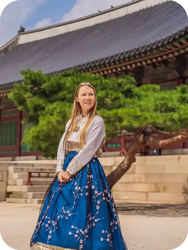 Austauschschülerin im Hanbok vor einem koreanischen Palast