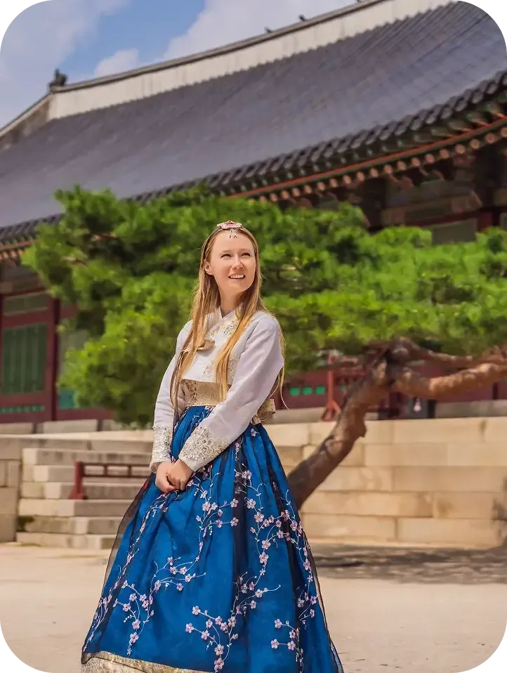 Austauschschülerin im Hanbok vor einem koreanischen Palast