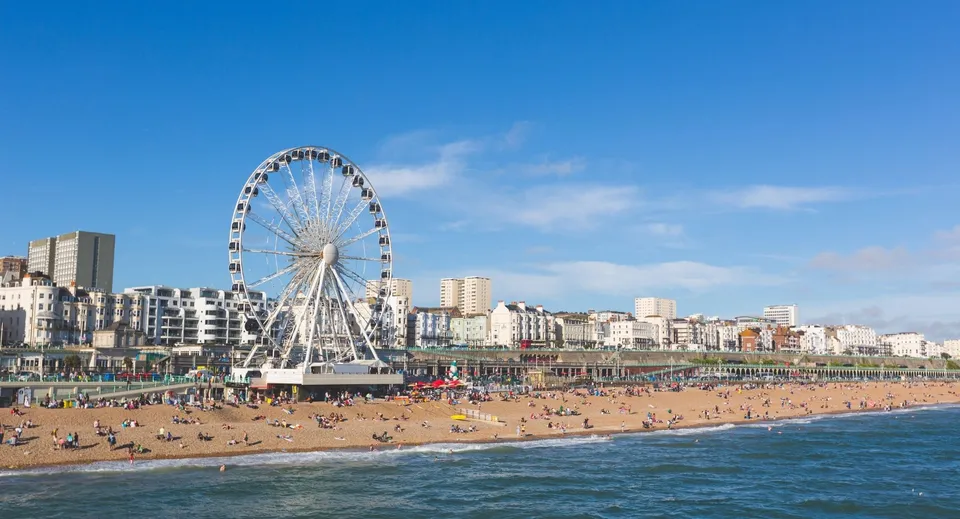 La spiaggia di Brighton vicino alla Roedean School con una ruota panoramica ed edifici sul lungomare.