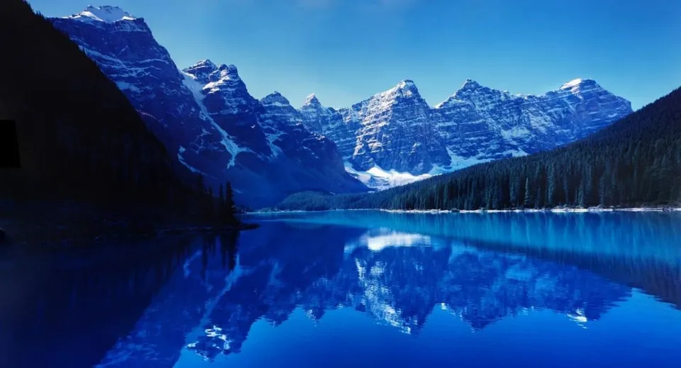 Un limpido lago alpino riflette le montagne innevate nei dintorni della Oakridge Secondary School.
