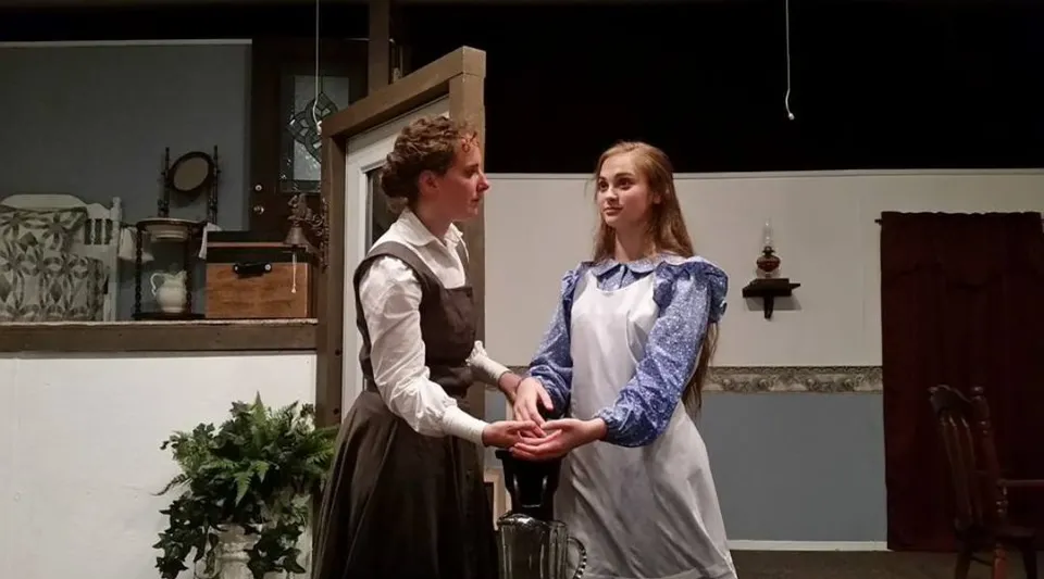 Un uomo e una donna si trovano in un ambiente interno rustico all'interno del campus della Maranatha Baptist Academy.