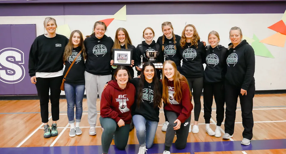 Un gruppo di giovani atlete posa in divisa sportiva nella palestra della Fernie Secondary School.