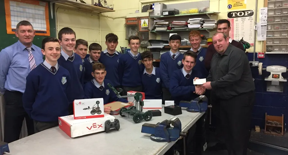 Studenti della Scoil Mhuire gan Smál lavorano insieme a un progetto di elettronica con vari dispositivi in un'aula.