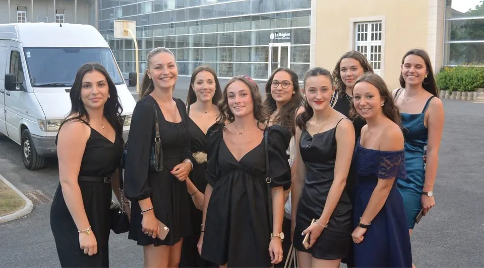 Un gruppo di giovani donne si trova davanti a un edificio con grandi vetrate nel campus del Lycée Sainte Thérèse.