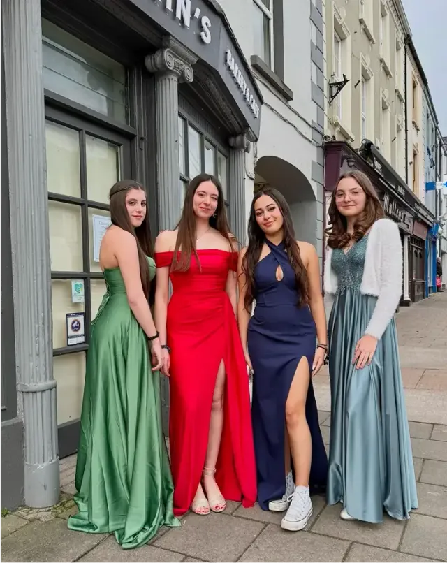 Quattro ragazze in eleganti abiti da sera per il ballo di fine anno in una via irlandese