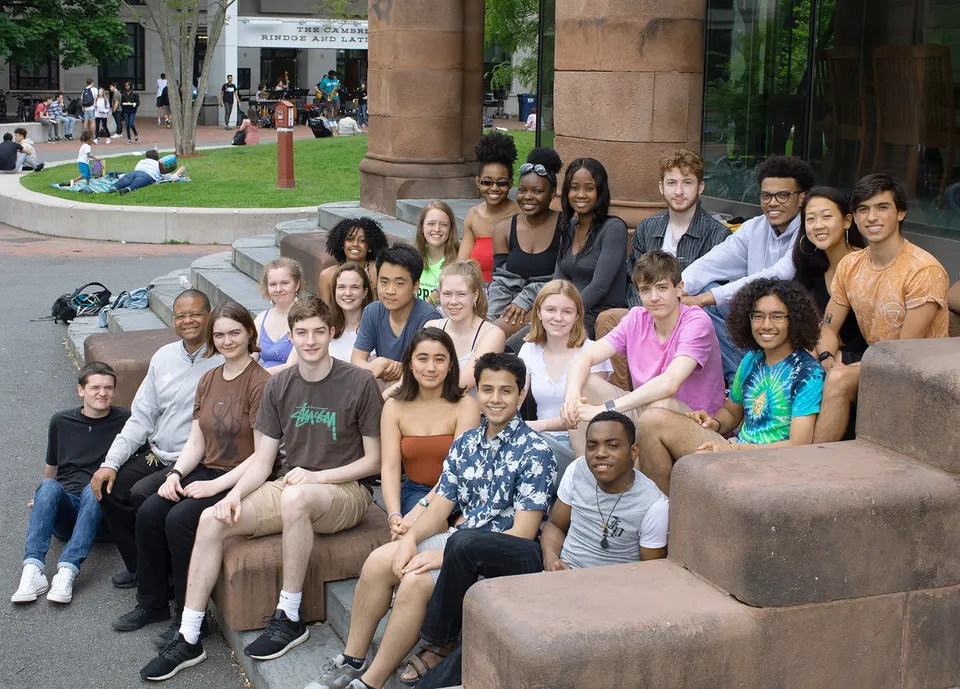 Un gruppo di studentesse e studenti della Cambridge Rindge and Latin High School si riunisce all'esterno con edifici e aree verdi sullo sfondo.