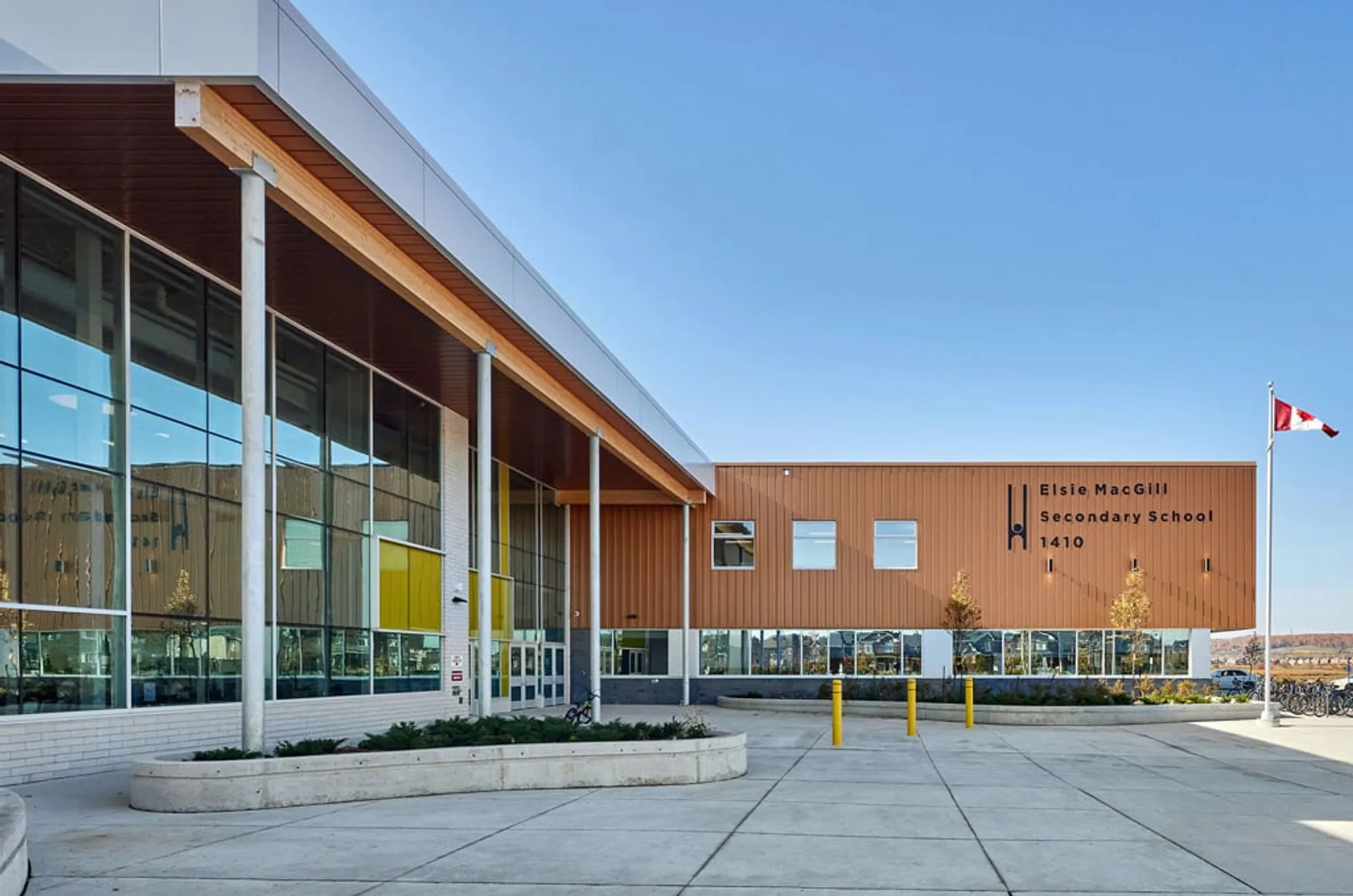 L'edificio scolastico moderno della Elsie MacGill Secondary School con grandi vetrate sotto un cielo limpido.