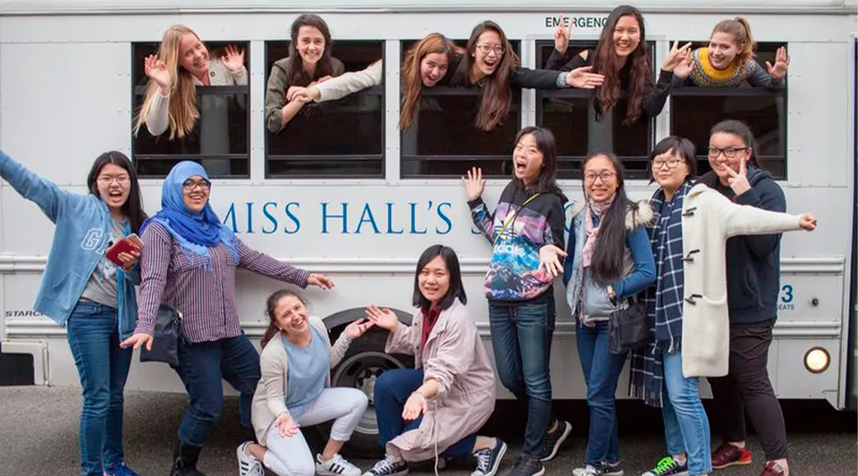 Un gruppo di studentesse posa davanti a un autobus con la scritta Miss Hall's School.