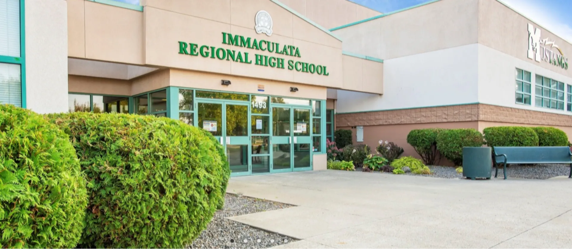 Si vede l'edificio moderno della Immaculata Regional School con un'area esterna ben curata e un ambiente verde.