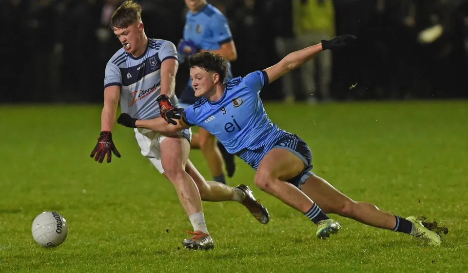 Due giocatori di rugby con maglie avversarie lottano per la palla sul campo da gioco del St. Gerald's College.
