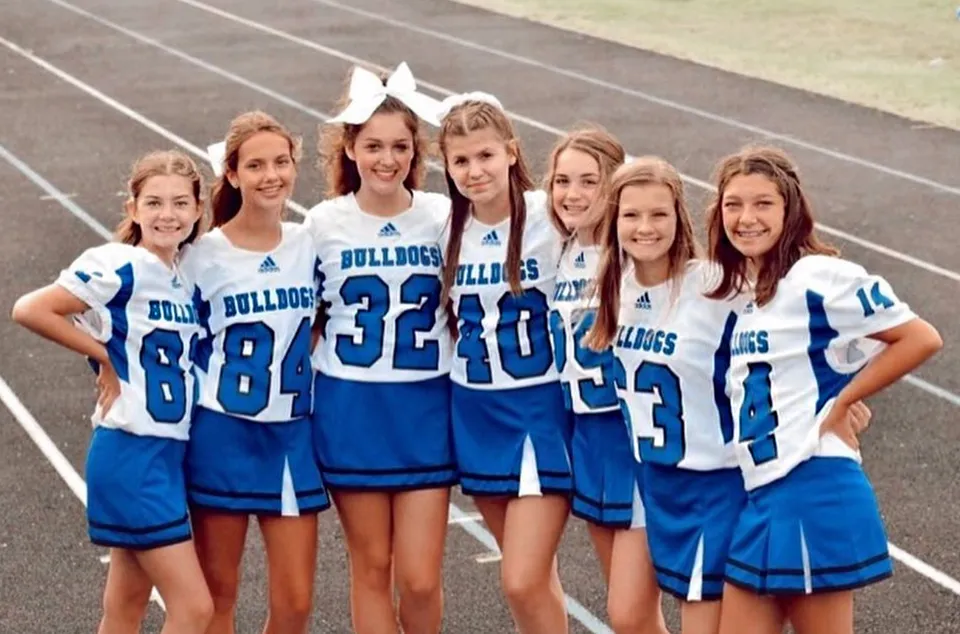 Un gruppo di giovani atlete in divisa da cheerleading posa insieme sul campo sportivo della Centerville Senior High School.