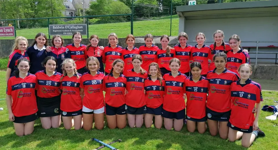 Un gruppo di giovani atlete posa su un campo erboso nel terreno della St. Mary's Secondary School a Macroom.