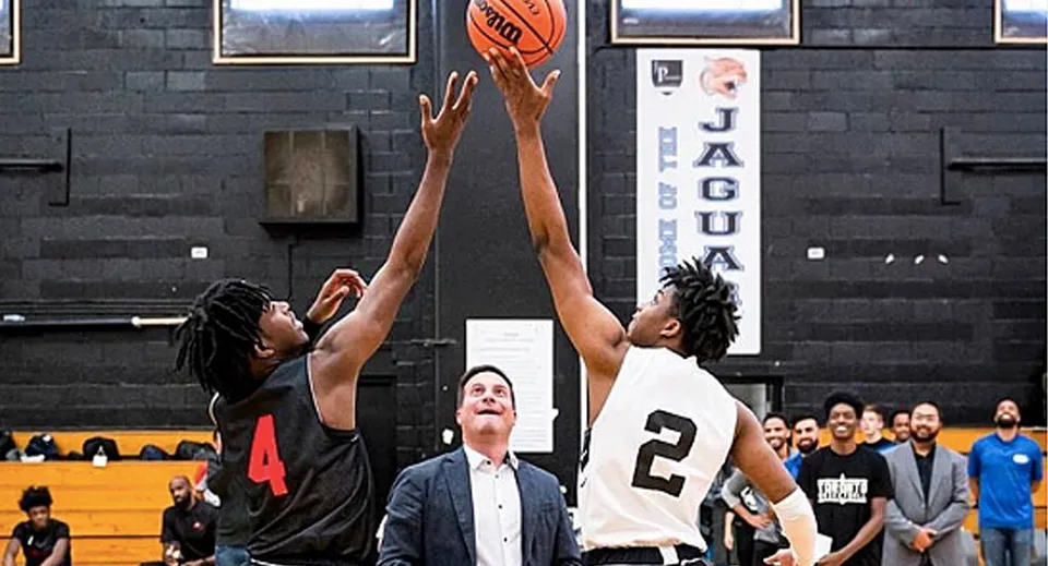 Due giocatori di basket lottano per la palla sul campo del John Polanyi Collegiate Institute.