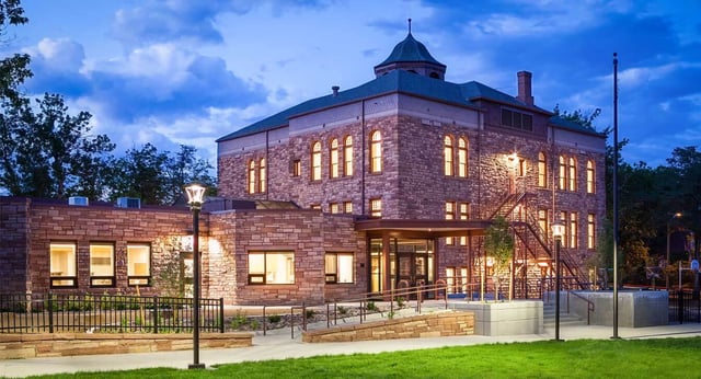 Ein großes steinernes Gebäude mit charakteristischem Turm steht auf dem Campus der Boulder Valley Public Schools.