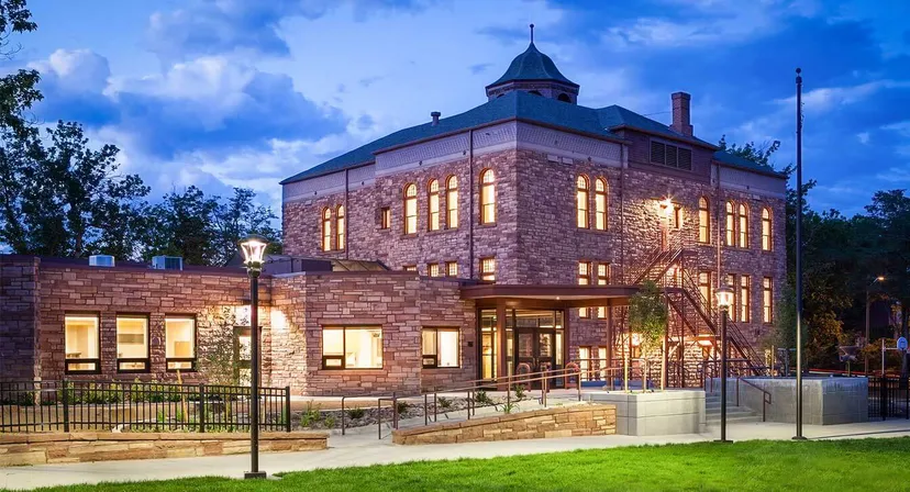 Un grande edificio in pietra con una caratteristica torre sorge sul campus delle Boulder Valley Public Schools.