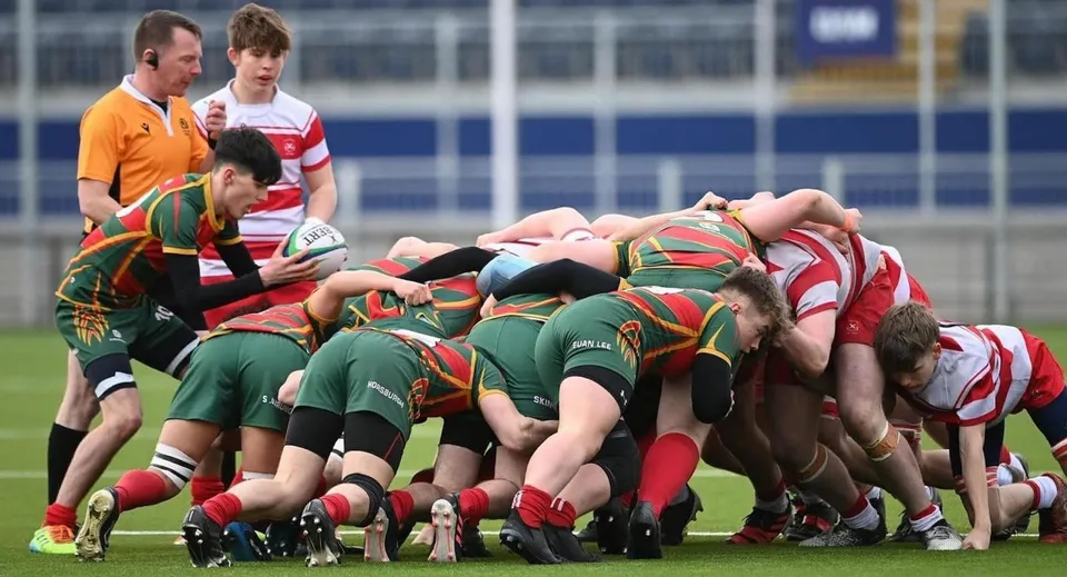Un gruppo di giocatori di rugby del Glenalmond College è ritratto durante una mischia sul campo da gioco.