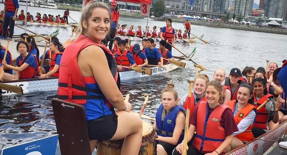 Studenti della Thomas Haney Secondary School siedono su un dragon boat indossando giubbotti salvagente.
