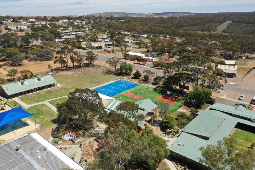 Il campo sportivo e la piscina si trovano davanti ad abitazioni ed edifici commerciali nel paesaggio collinare vicino alla Ravensthorpe District High School.