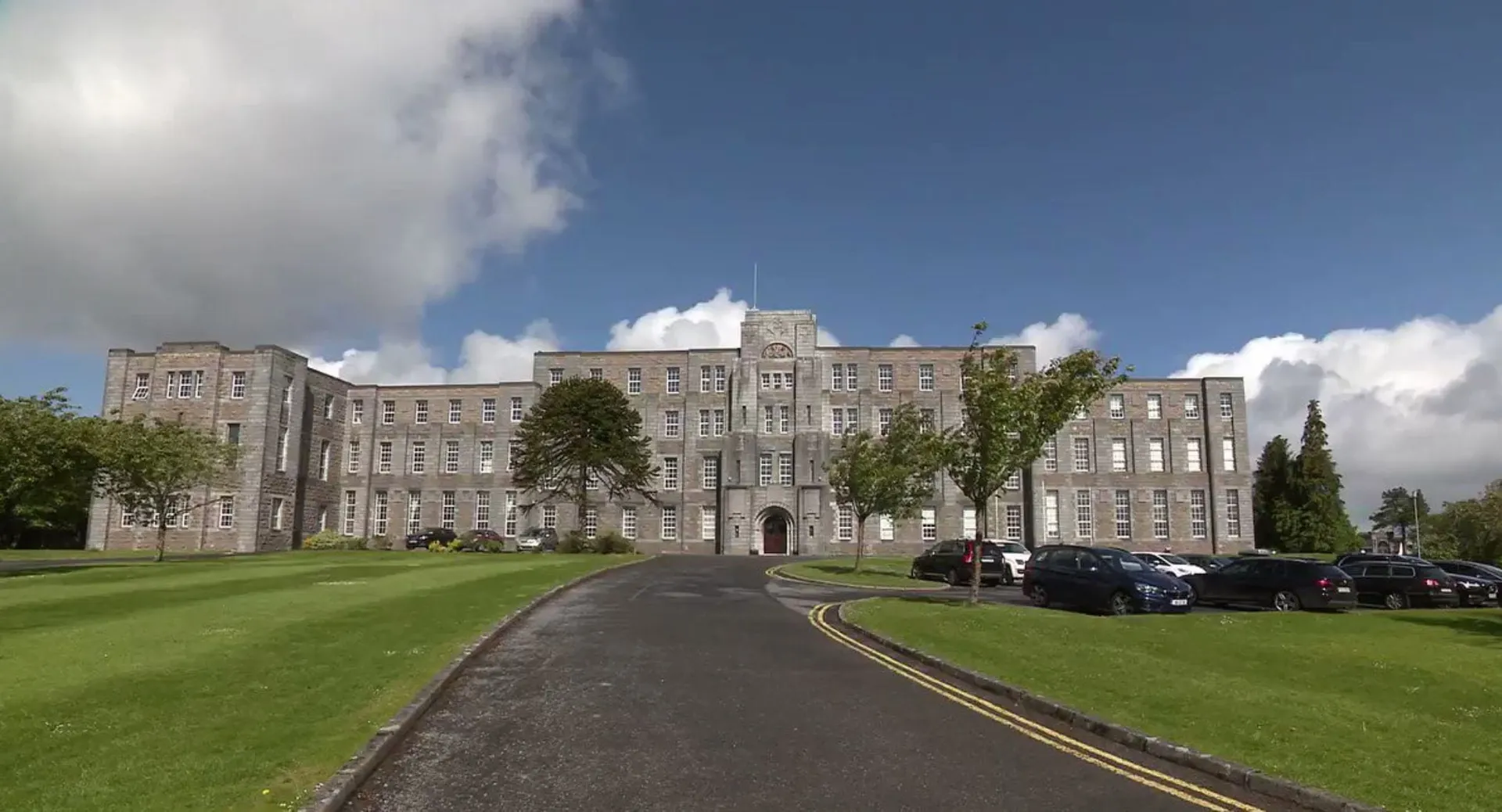 L'edificio principale storico con torre nel terreno del St. Marys College Galway è circondato da prato e alberi.