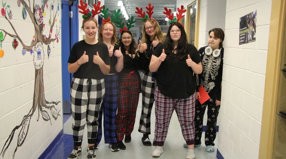 Un gruppo di studentesse della Picture Butte High School è insieme nel corridoio decorato a festa.