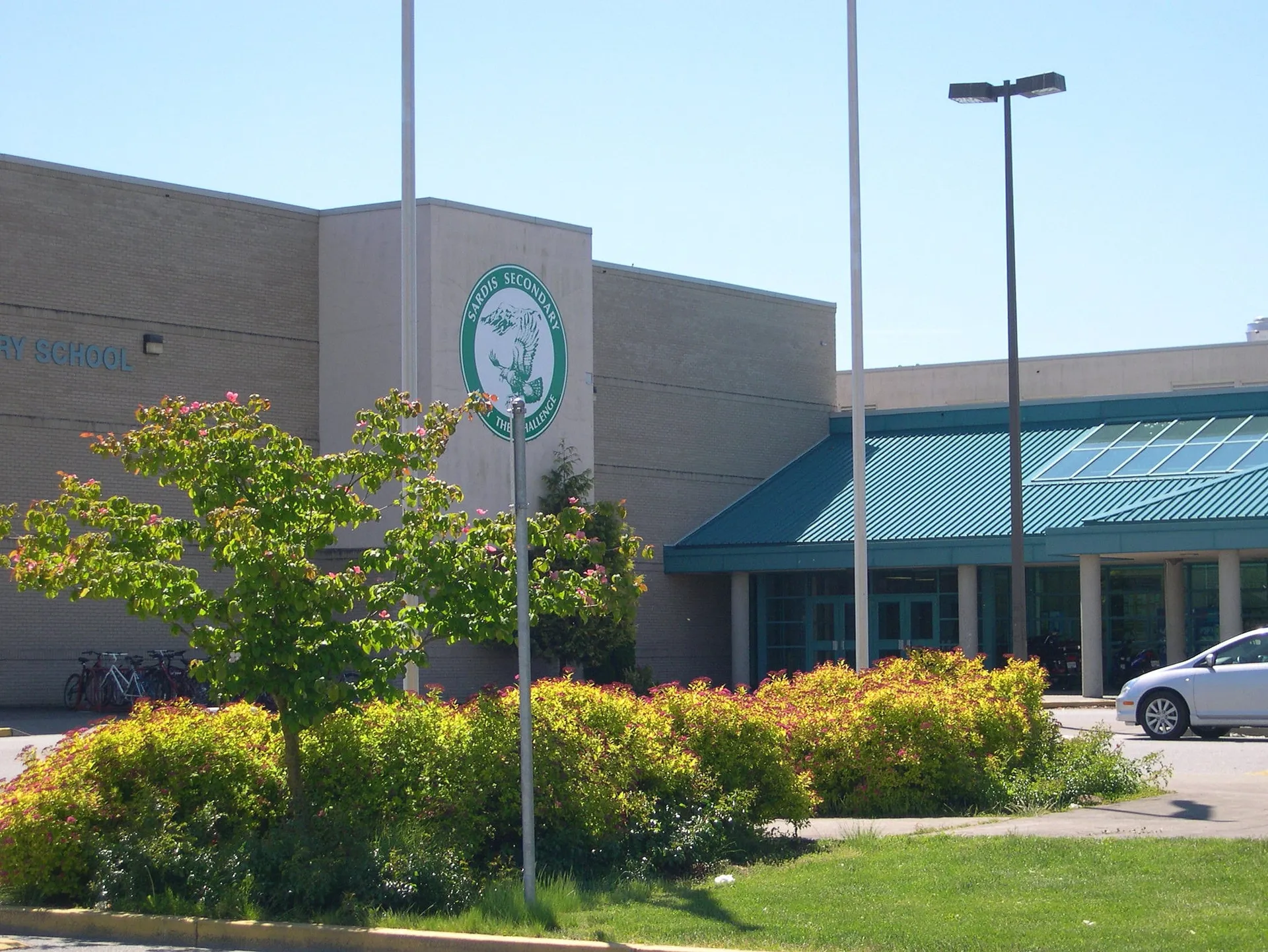 Il grande edificio con il logo verde nel campus della Sardis Secondary School è circondato da un verde lussureggiante.